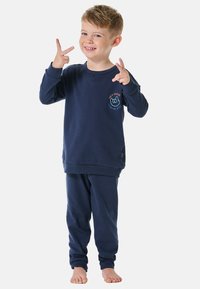 Navyblaues Loungewear-Set für Kinder aus weichem Material, mit langen Ärmeln, gerippten Bündchen und einem verspielten Logo auf dem Shirt. Die Hose hat eine lässige Passform.