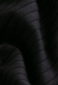 Tela negra con textura y un sutil patrón acanalado, que presenta una superficie suave y aterciopelada con un color uniforme en toda la pieza.