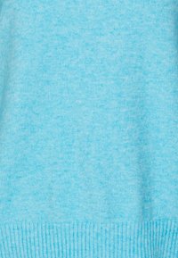 Light blue knitted sweater, featuring a soft texture, ribbed hem, and a slightly heathered appearance with a smooth finish.