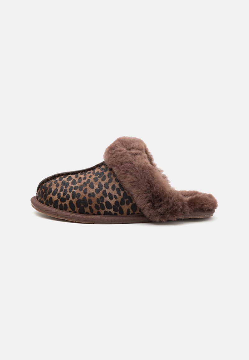 Pantofole con stampa leopardata, bordatura in pelliccia sintetica marrone, esterno morbido, design aperto sul retro e suola in gomma resistente. Motivo a stampa animale testurizzato.