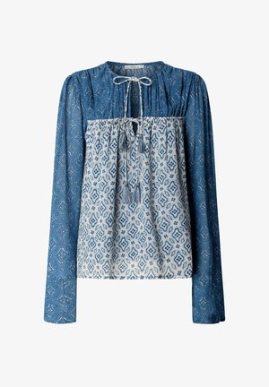 Blau-weißes langärmeliges Blusentop mit geometrischen Mustern, versehen mit zwei gebundenen Quastenbändern am Halsausschnitt und in der Mitte der Brust.