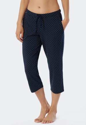 Navy blue capri pants with white polka dots, elastic waistband, drawstring, side pockets, and smooth fabric texture.