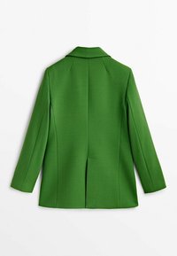 Zielony żakiet szyty na miarę z usztywnionym kołnierzem, długimi rękawami i rozcięciem z tyłu. Wykonany z gładkiego materiału, charakteryzuje się minimalistycznym fasonem i brakiem wzorów.