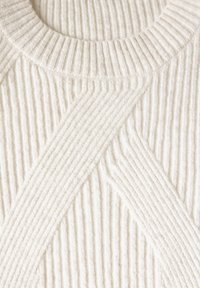 Sweter z dzianiny w jasnym kremie, z teksturowanym pionowym i ukośnym prążkowaniem, z okrągłym dekoltem. Miękki i przytulny materiał.