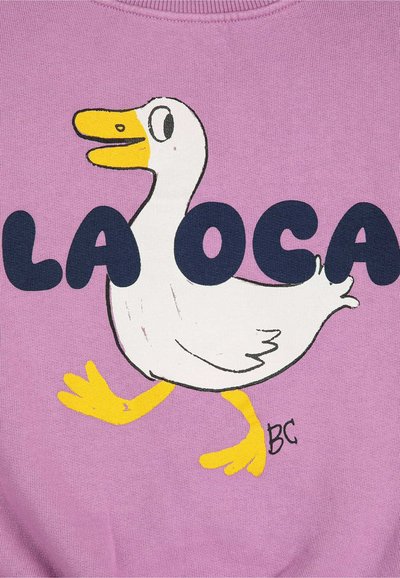 Fialová mikina so bielym karikatúrnym kačicom so žltým zobákom a nohami, spolu s výrazným námorníckym textom, ktorý znie "LA OCA."