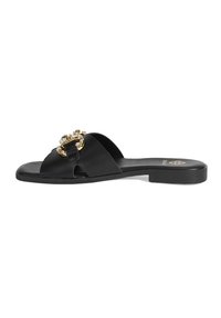 Sandal noir à semelle plate avec un design à bout ouvert, ornée d'une boucle décorative dorée et de strass transparents. Matériau lisse.