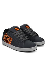 Graue Sneakers aus strukturiertem Synthetikmaterial, mit einem orangefarbenen Logo, grauen Schnürsenkeln und einer weißen Gummisohle.