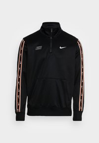 Černá mikina Nike s čtvrtinovým zipem a bílým logem, s oranžovými a bílými pruhy se značkou na rukávech a přední kapsou.