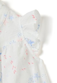 Weißes Stoffoberteil mit strukturierter Oberfläche, das mit rosa und blauen Sternmustern sowie Rüschenärmeln für zusätzliche Details versehen ist.
