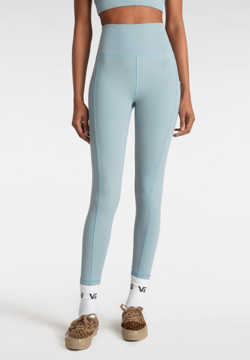 Leggings a vita alta di colore azzurro realizzati in tessuto elastico, con cuciture di un blu chiaro a contrasto e una cintura testurizzata. Senza logo visibile.