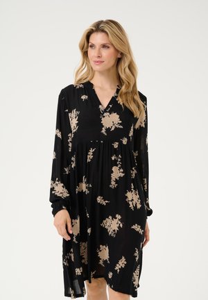 Schwarzes Kleid mit V-Ausschnitt und langen Ärmeln, mit einem floralen Muster in Beige. Fließendes Design, weicher Stoff und geraffte Taillenpartie.
