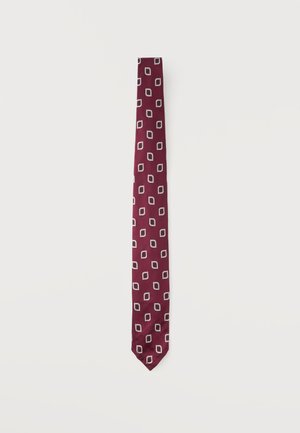 Cravate fine bordeaux avec un motif répétitif de formes géométriques blanches sur un fond clair uni.