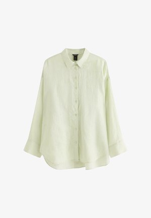 Lysegrøn oversize skjorte med lange ærmer, krave og let buet nederkant, vist mod en hvid baggrund.