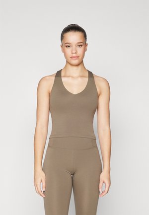 Brown sleeveless athletic top with a V-neck, fitted design, and smooth fabric. Paired with matching fitted leggings, both have clean seams.