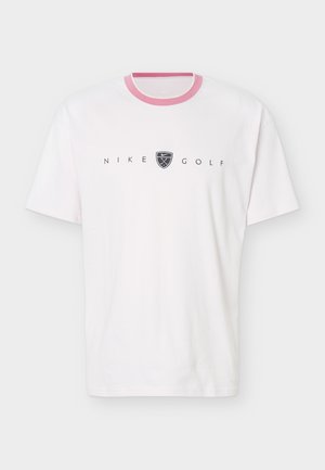 Biały T-shirt z krótkim rękawem, różową lamówką przy szyi, czarnym napisem "Nike Golf" oraz logo w kształcie tarczy z skrzyżowanymi kijami golfowymi na środku klatki piersiowej.