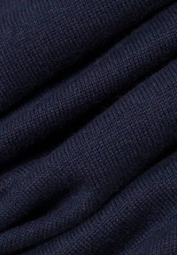 Dunkelblaues Strickgewebe mit feiner Textur, das gleichmäßig verteilte Stiche und subtile Farbvariationen zeigt. Weiches und flexibles Material.