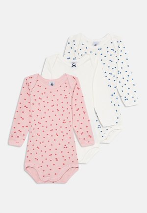 Drei langärmlige Baby-Bodysuits, zwei weiße mit blauen und schlichten Mustern, einer rosa mit kleinen roten Punkten, flach auf einem weißen Hintergrund ausgelegt.