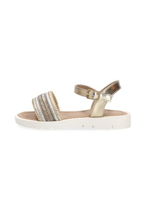 Sandalia para niñas con suela blanca, tiras metálicas doradas en el tobillo con hebilla, y tira frontal beige decorada con patrones trenzados en plata y crema.