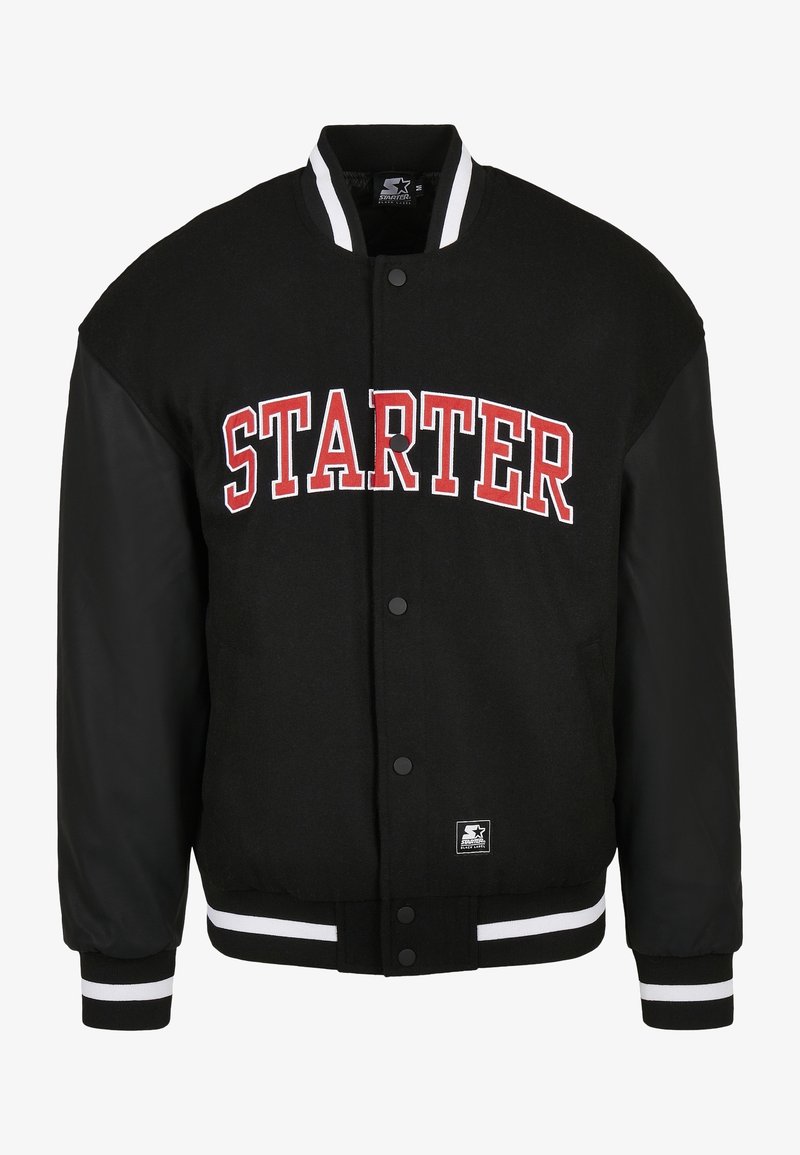 Veste universitaire noire avec col et poignets à rayures blanches, texte rouge "STARTER" sur la poitrine, boutons-pression et écusson près de l'ourlet inférieur.