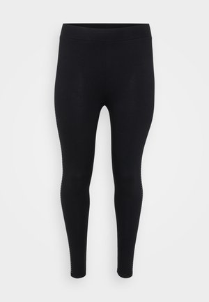 Svarte leggings med en glatt tekstur, høy midje og en tettsittende fasong. Har subtile detaljer langs sømmene.