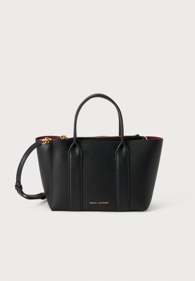 Черна кожена чанта Marc Jacobs с две горни дръжки, златист цип и подвижна презрамка за рамо, с червена вътрешна подплата.