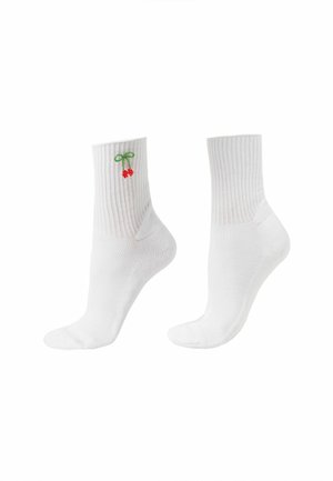 Paire de chaussettes blanches côtelées montantes avec une petite broderie de cerise rouge et de tige verte près du haut sur une chaussette.