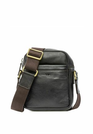 Czarna skórzana torba na ramię z brązowym regulowanym paskiem i mosiężnymi klamrami, wyposażona w przednią kieszeń i kompaktowy design.