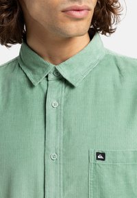 Groene corduroy shirt met een button-down kraag, een voorzak met een logo en gestructureerde strepen. Zachte stof met een gladde afwerking.