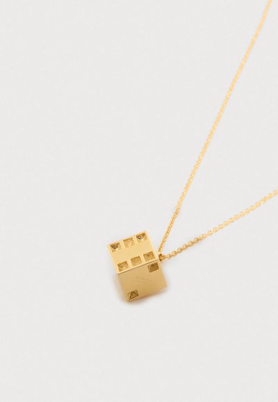 Χρυσό κολιέ με μενταγιόν σε σχήμα ζαριού δύο κομματιών που δείχνει πέντε και δύο κουκκίδες σε λευκό φόντο.