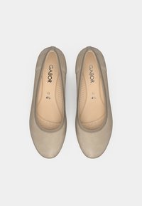 Beżowe baleriny Gabor z gładką skórzaną cholewką, zaokrąglonym noskiem i perforowaną wkładką. Logo nadrukowane wewnątrz, minimalistyczny design.