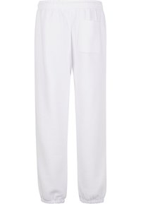 Witte joggingsbroek van zacht materiaal, met een elastische tailleband en een enkele achterzak. Aangesnoerde pijpen met elastische boorden.