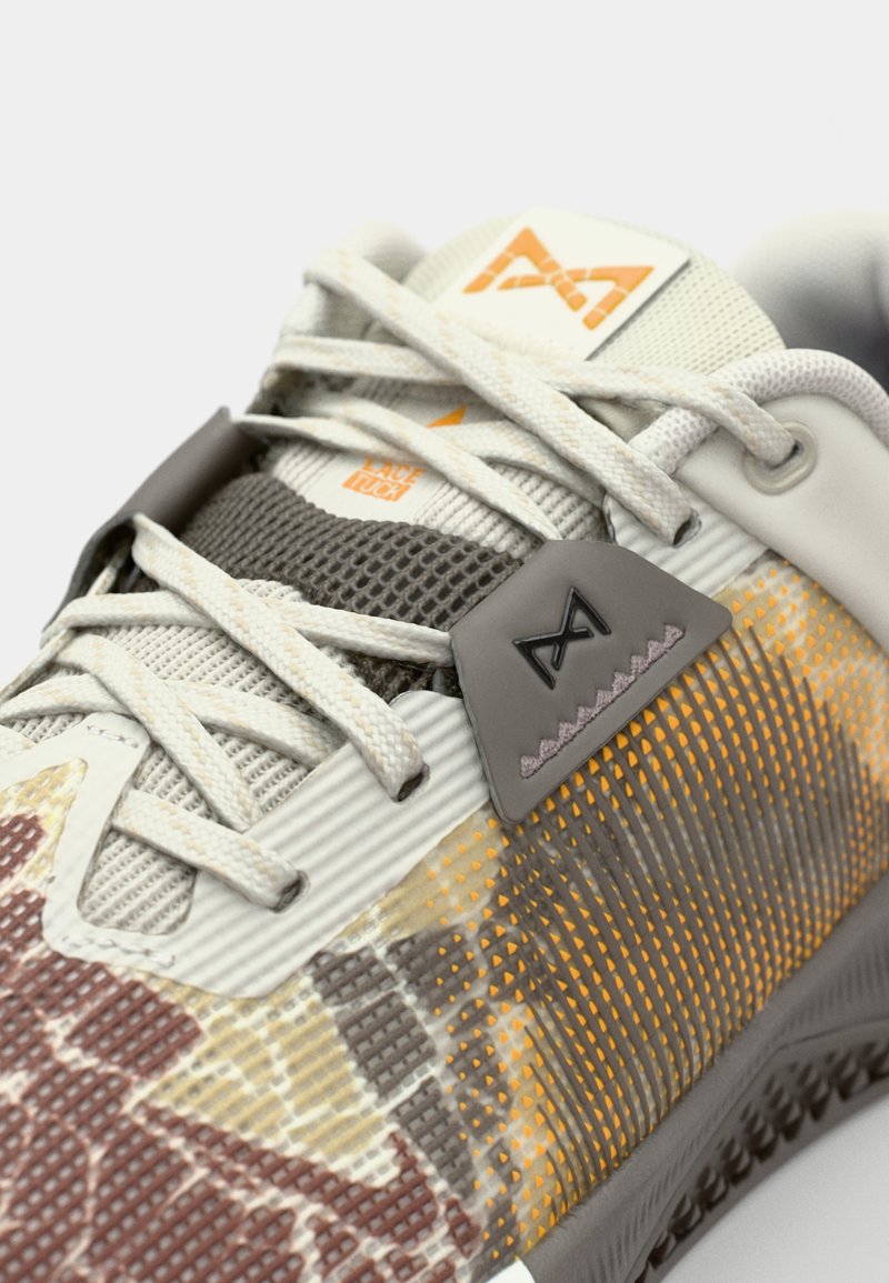 Sneaker med en texturerad, flerfärgad mesh-överdel i grå, beige och orange nyanser. Inkluderar snörningssystem och logotypdetalj.