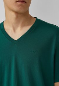 Groene V-hals T-shirt gemaakt van zacht materiaal; voorzien van een tonal s.Oliver-logo op de borst; gladde textuur en casual pasvorm.