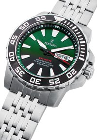 Montre de plongée en acier inoxydable avec un cadran vert, affichage de la date, lunette noire et marqueurs d'heure blancs. Bracelet à maillons avec une finition polie.