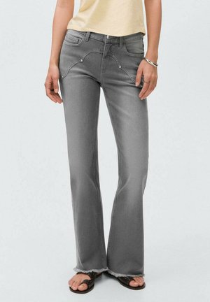 Jeans grigi con gamba svasata e orlo sfrangiato, design a cinque tasche e dettagli di cucitura curva. Realizzati in un morbido materiale denim.