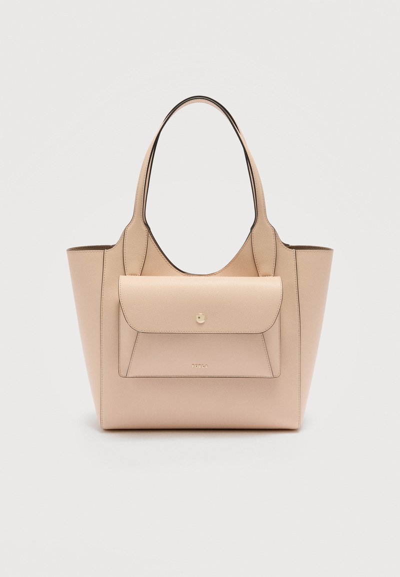 Μπεζ δερμάτινη τσάντα tote με εμπρόσθια θήκη με καπάκι, διπλές λαβές και διακριτικά χρυσά γράμματα με λογότυπο σε απλό ανοιχτό φόντο.