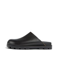 Chaussures noires en cuir à enfiler avec un bout arrondi, dotées d'une semelle en caoutchouc légèrement surélevée et d'un design minimaliste, sans matériel visible.