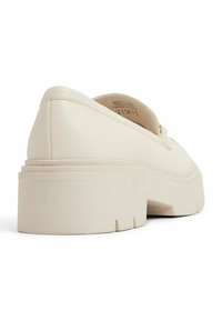 Romige platform schoenen van soepel materiaal. Voorzien van een dikke zool met subtiele ribbels en een afgeronde neuzen.