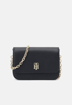 Black textured leather crossbody bag with gold chain strap and gold double-T logo centered on the front flap.