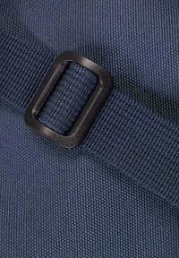 Tessuto testurizzato blu navy con una fibbia in metallo nero su una cintura, che mostra un motivo intrecciato e cuciture rinforzate.