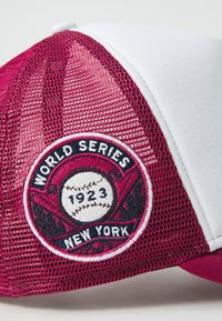 Cappellino da baseball in rete rossa con un pannello frontale bianco, caratterizzato da un logo ricamato "World Series 1923 New York" di lato.