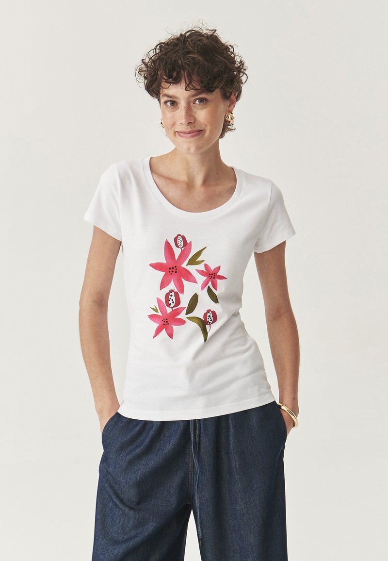 T-shirt bianco a maniche corte con stampa floreale in rosa e verde. Il design include fiori e foglie stilizzati.