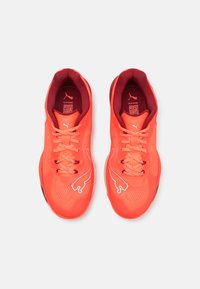 Scarpe da ginnastica di un brillante arancione con superficie testurizzata, caratterizzate da accenti e lacci rosa. Logo iconico esposto sul lato.