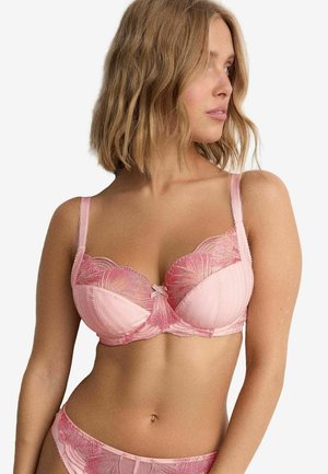 Pink lace bra with structured cups and floral embroidery, featuring adjustable straps and a center bow detail. Smooth satin band below.