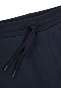 Navy blue cotton joggers with a drawstring waist, featuring a smooth texture and side pockets with stitched seams.