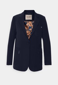 Blazer bleu marine à coupe ajustée, fermeture à un bouton, deux poches avant zippées, et doublure en satin floral dans des tons marron et bleu.