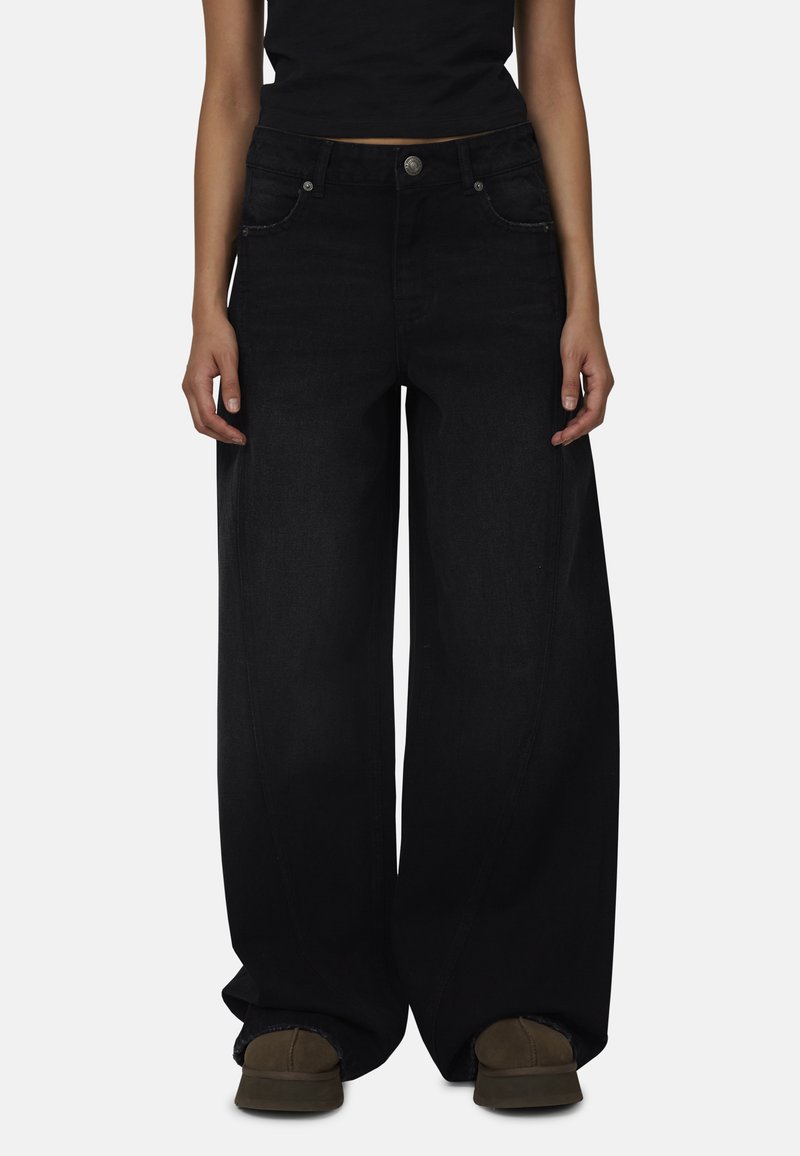 Zwarte denim jeans met wijde pijpen, voorzakken, metalen knoopsluiting en subtiele stikdetails. Gemaakt van zachte, duurzame stof.