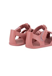 Pink rubber sandals with an open design, featuring adjustable straps and a textured insole. Smooth finish with cut-out details.