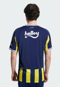 Tamsiai mėlyna futbolo marškinė su geltonais akcentais, dryžuotomis rankovėmis ir dideliu baltu "halley" logotipu ant nugaros, pagaminti iš lengvos medžiagos.