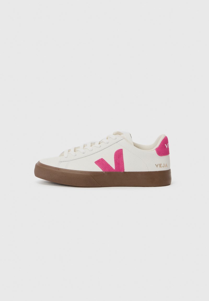 White canvas sneaker with a pink logo and accents. Features a textured brown rubber sole and flat laces. Minimalist design.